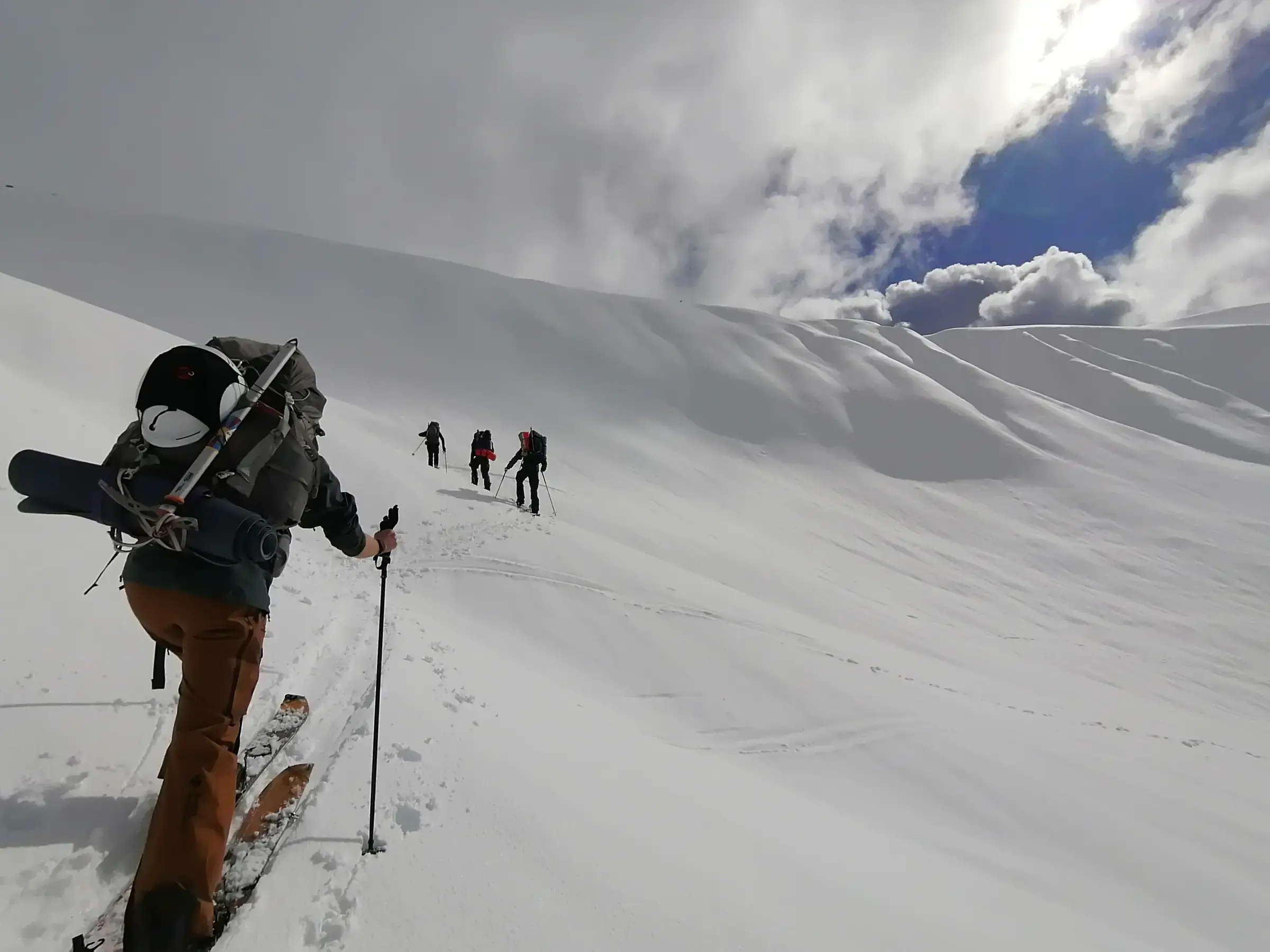 Backcountry tourers skinning up an alpine ridge